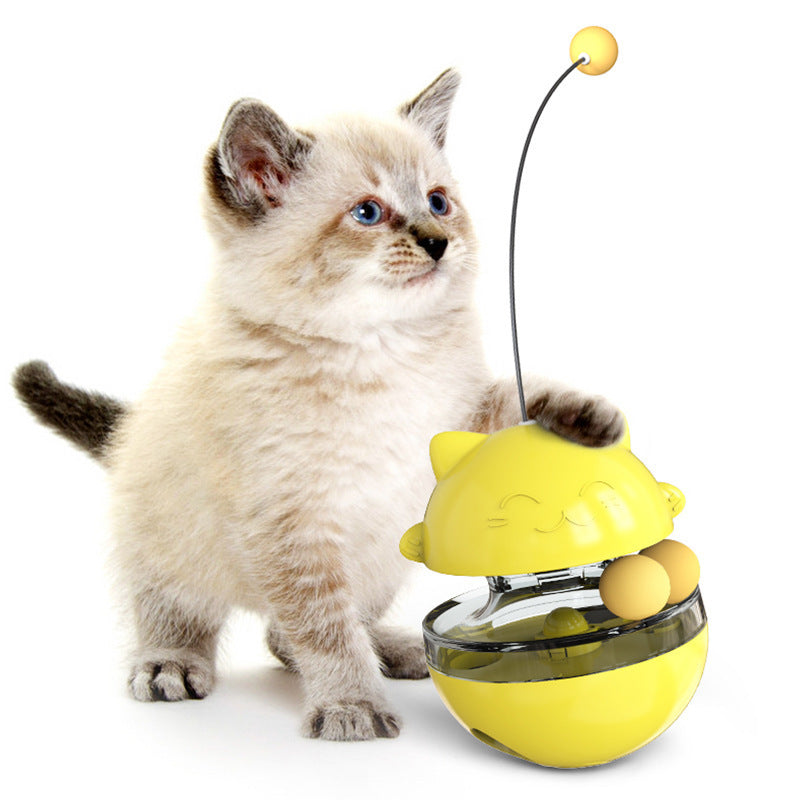 Kitten playing with a yellow cat toy on a white background