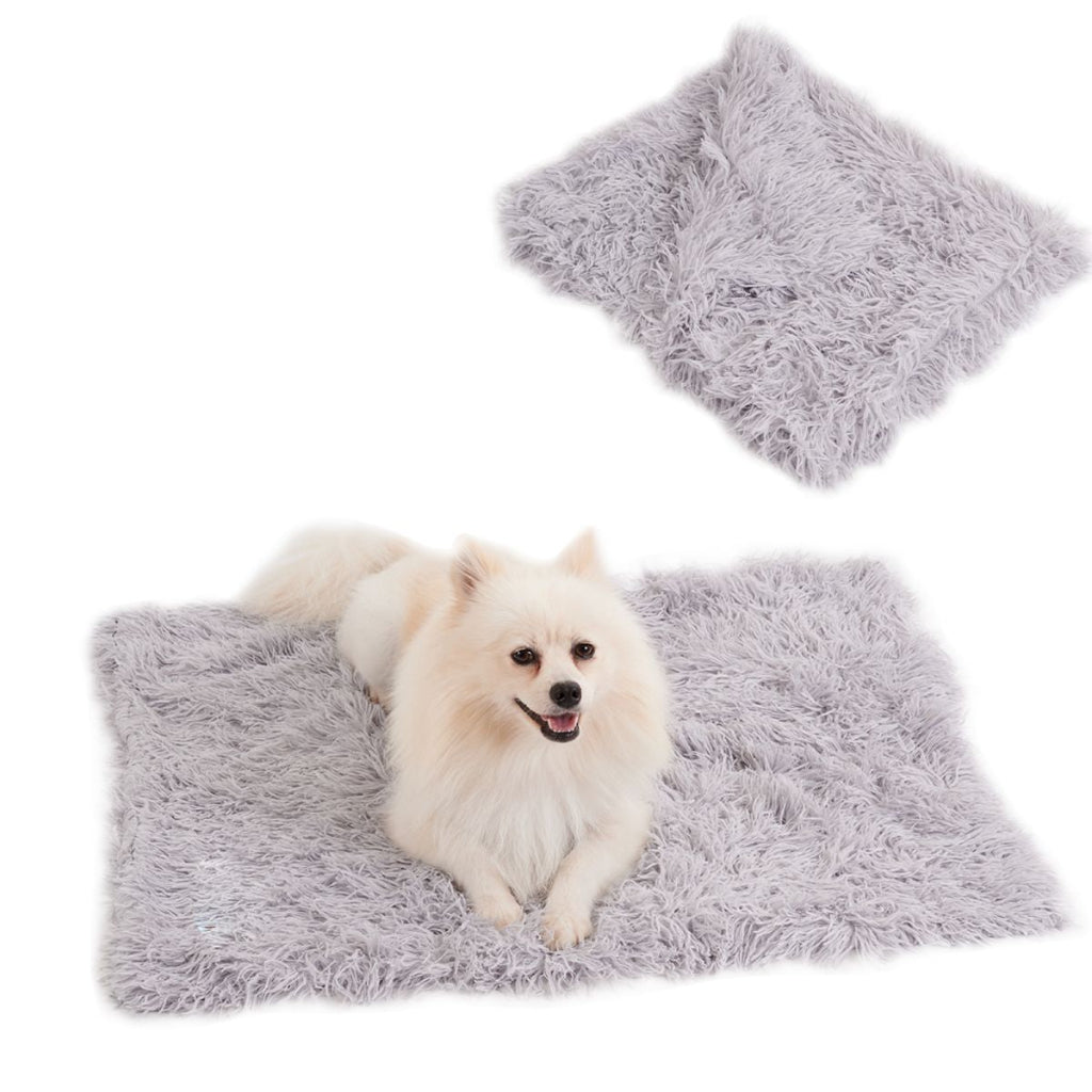 Fluffy gray pet mat with a small white dog sitting on it, against a white background